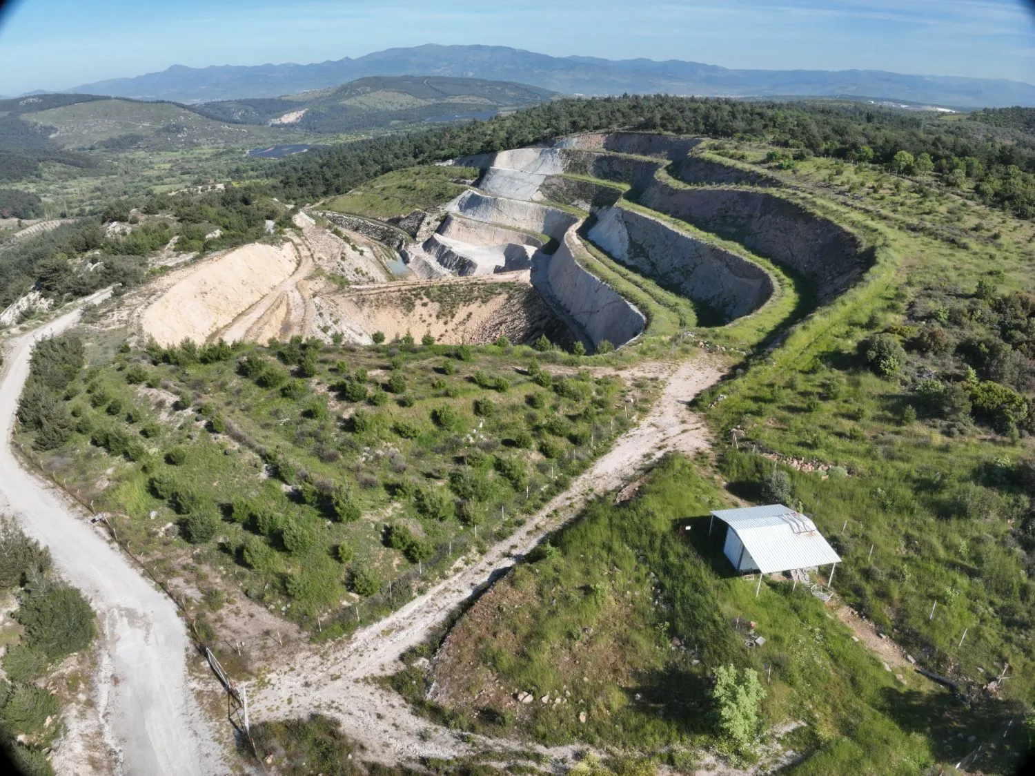 Aerial view of a rehabilitated perlite quarry with replanted benches and slopes